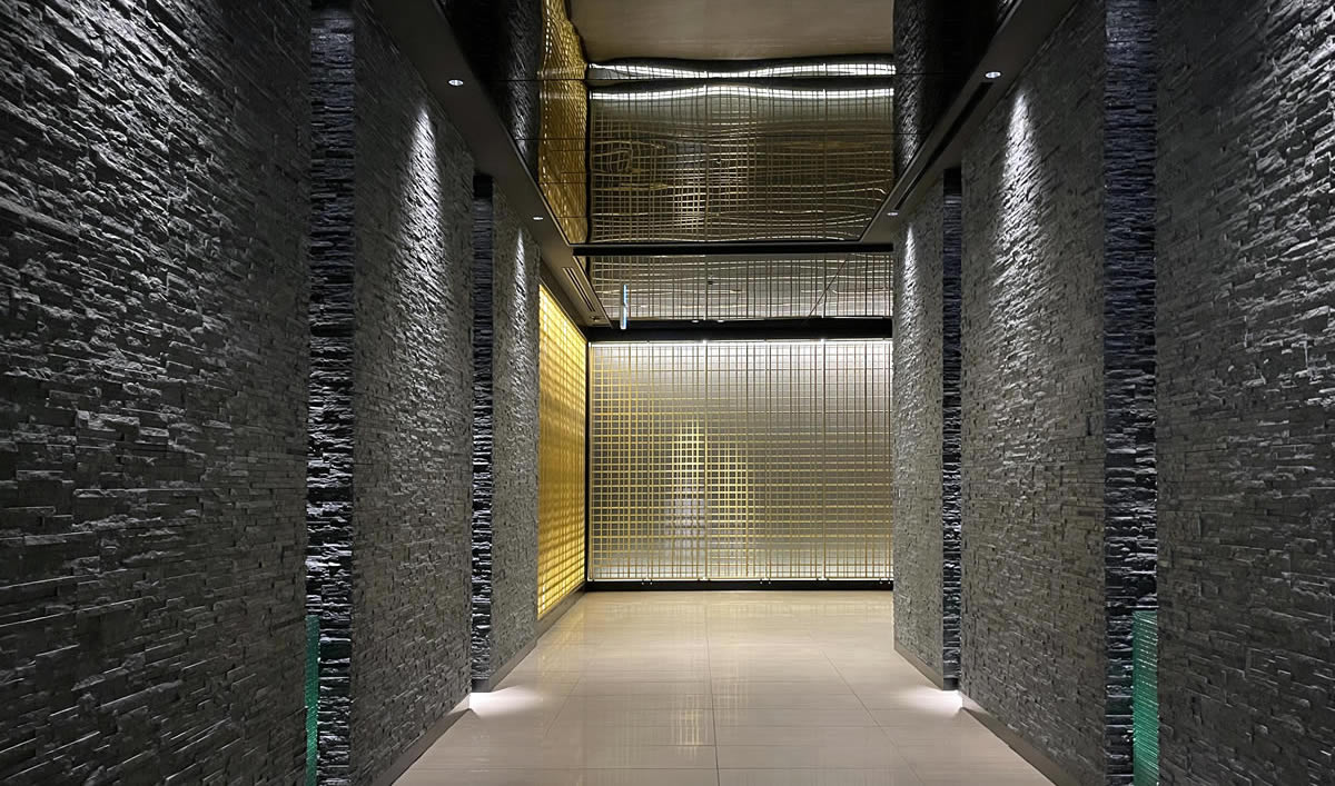 ホテルトラスティプレミア熊本の「黒」を基調にした壁とゴールドの格子デザインが重厚感あふれる空間