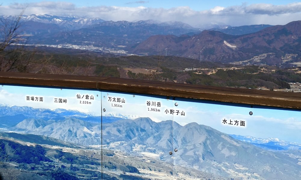 ときめきデッキの山名案内パネルと遠くの山並み