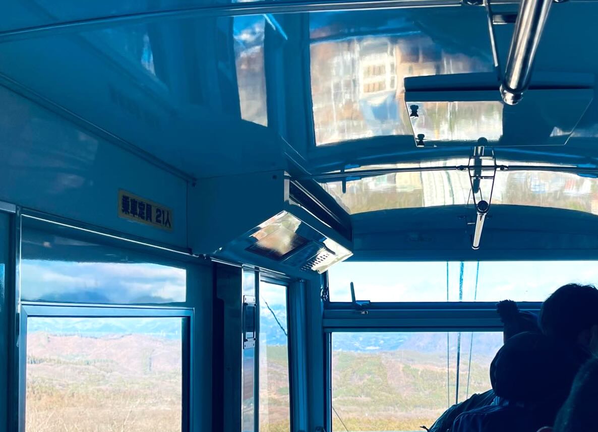伊香保ロープウェイ車内の様子と窓越しに広がる山の景色