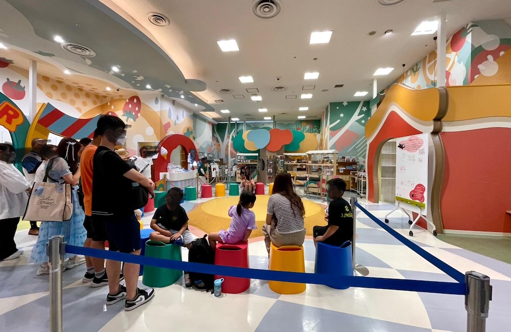 くまモンスクエアのステージ会場。カラフルなイスに座る子どもたちと観客の様子。