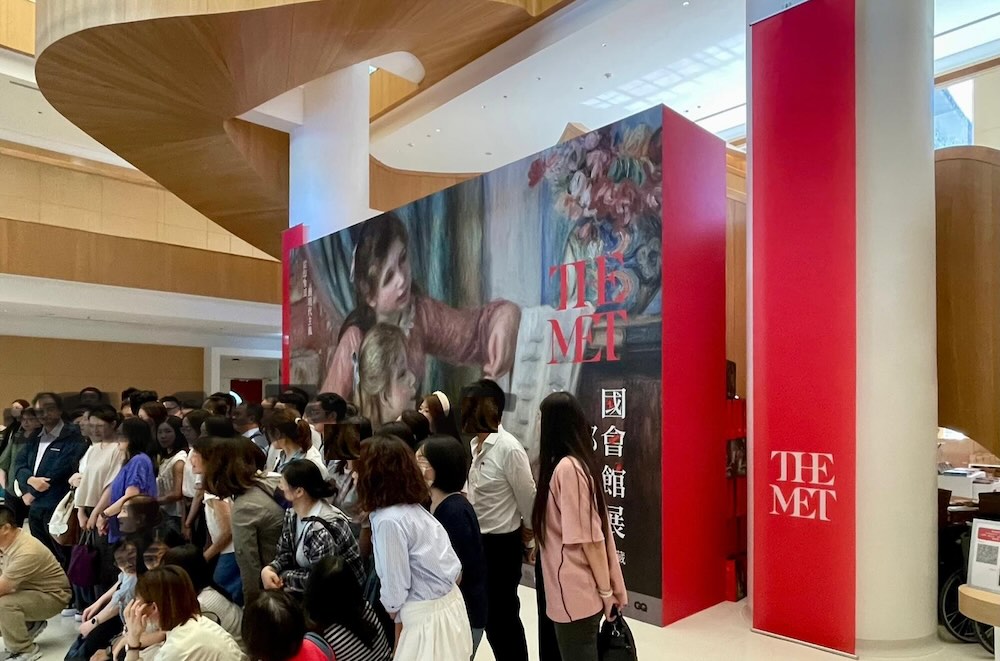 吹き抜け横の大型ビジュアル前。多くの来場者が記念撮影で賑わうフォトスポット