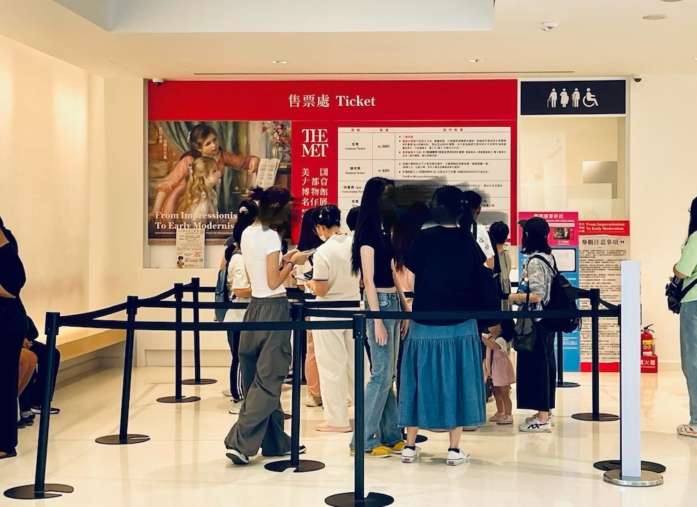 メトロポリタン美術館展のチケット売場。赤い案内板の前に整然と並ぶ来場者の列