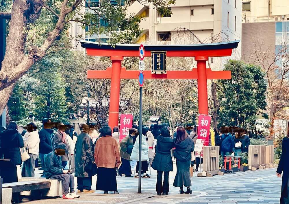 高層ビルの間に現れる福徳神社の朱色の鳥居