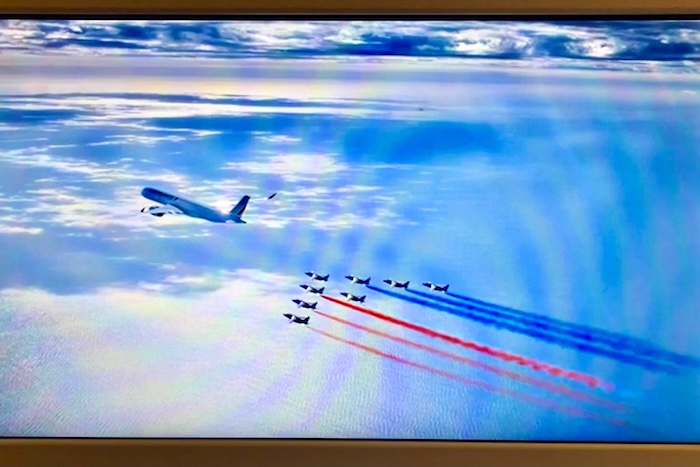 夕暮れの光の中で、水平線と平行に飛ぶA350とアルファジェット。トリコロールのラインが平行に伸びる芸術的な構図。