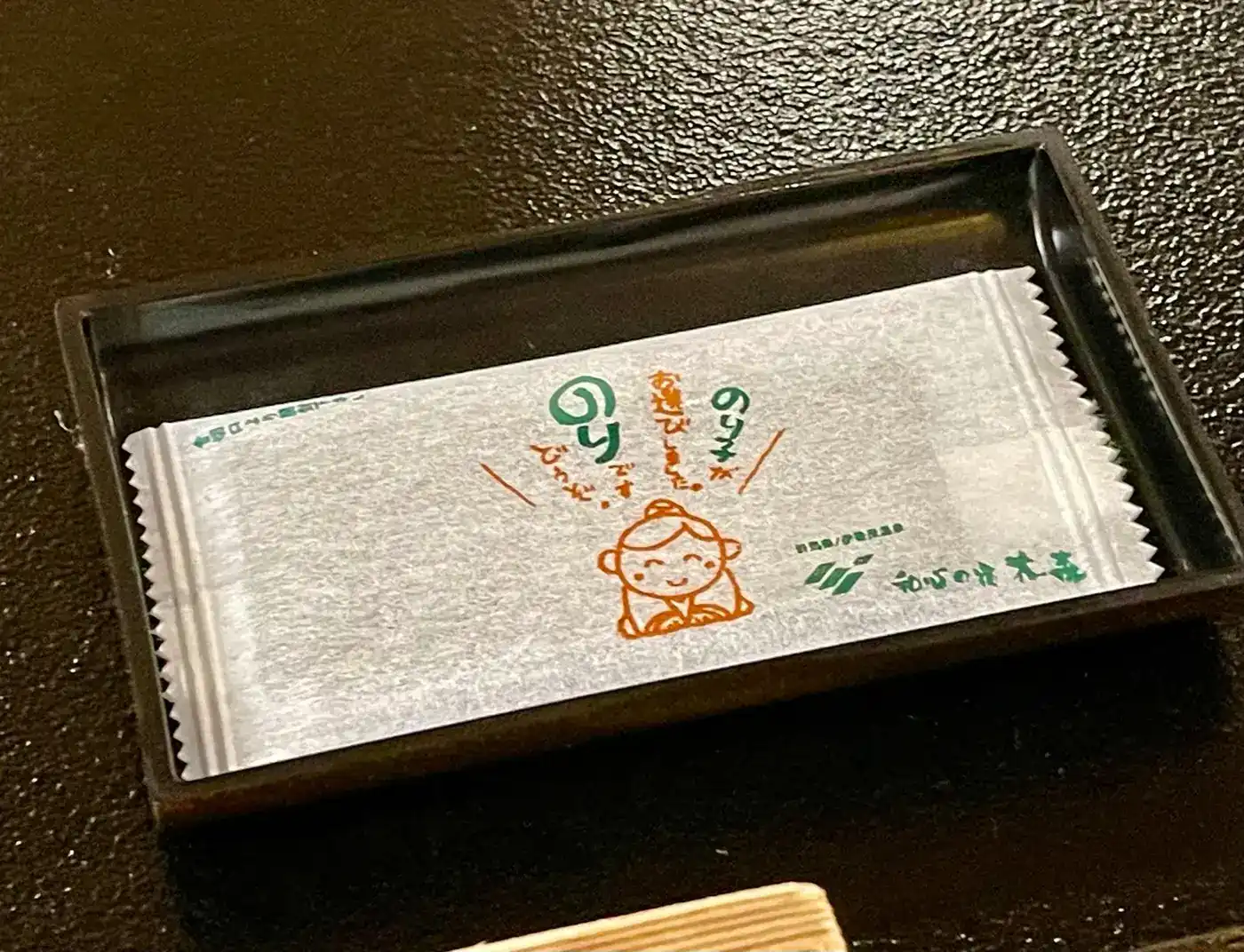 のり子ちゃんのイラストが描かれたおしぼりの包み紙