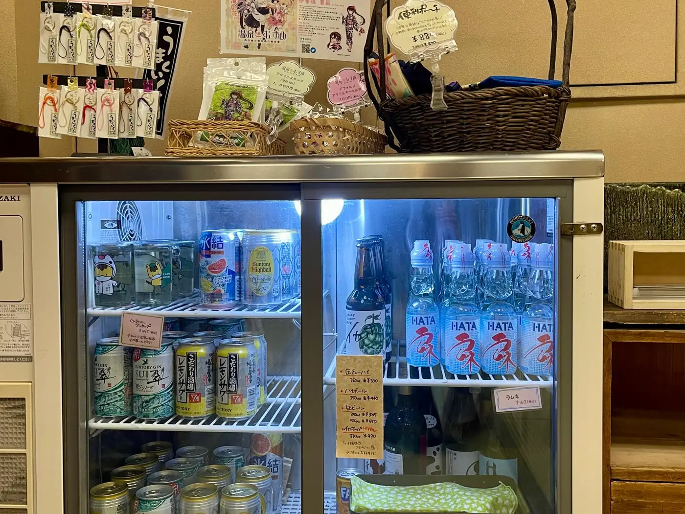 ドリンクの冷蔵ショーケースと、上に置かれた土産物