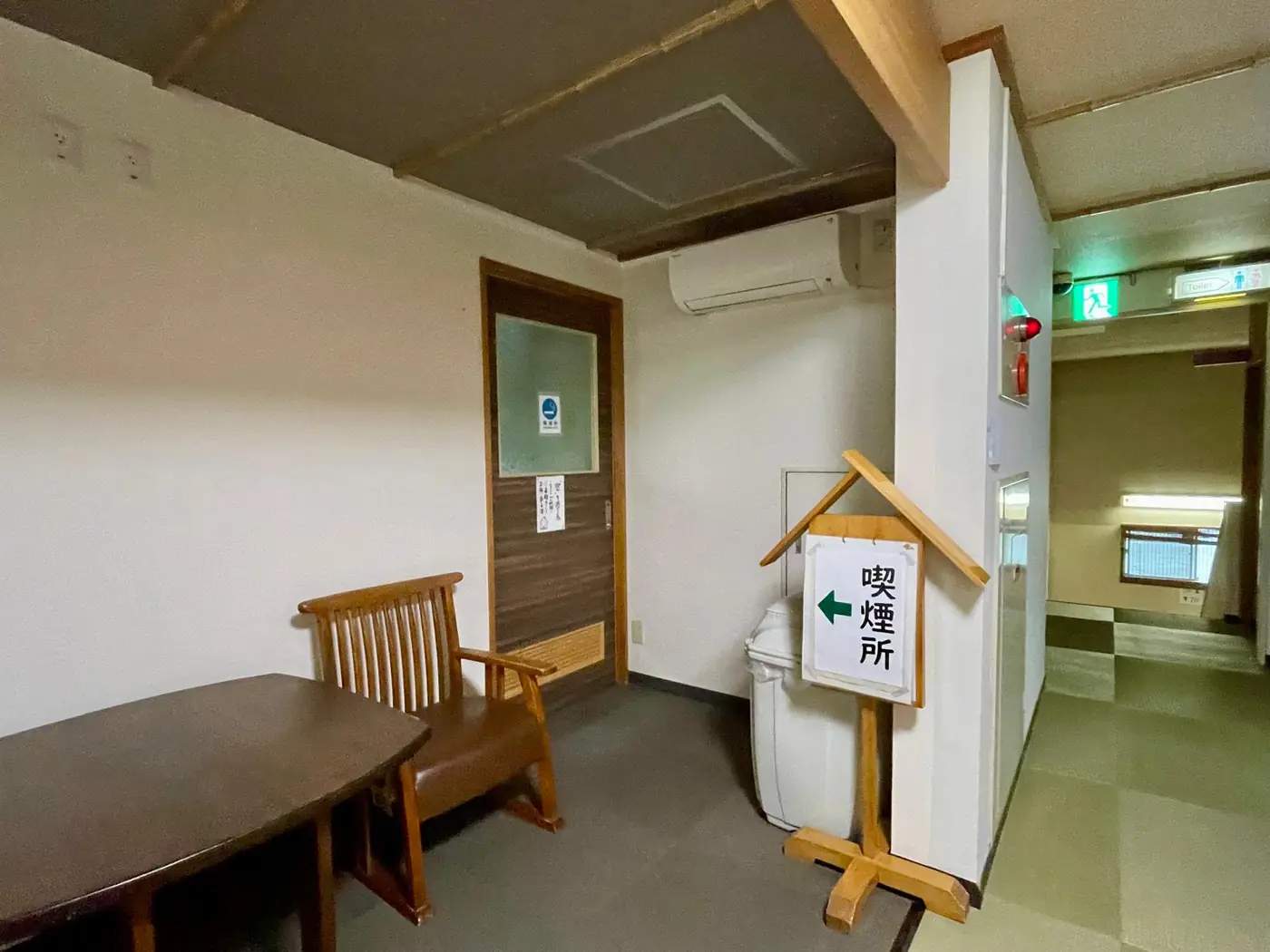 喫煙所への案内板とテーブル、椅子