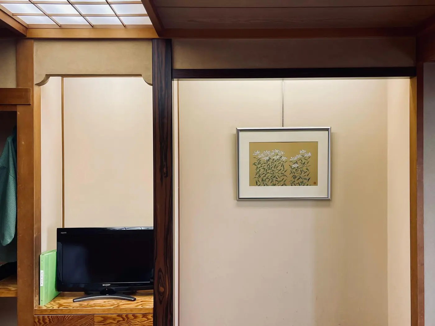 床の間のテレビと、壁に飾られた花の絵
