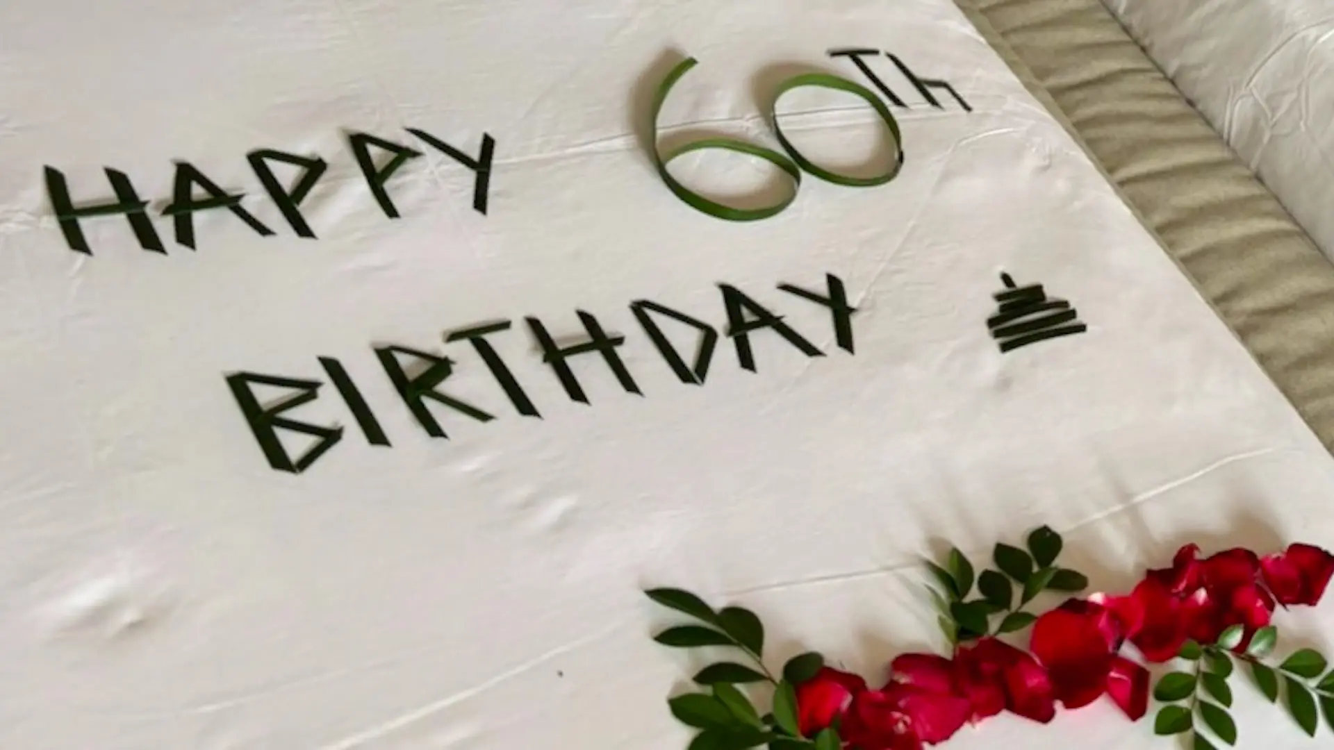 ヴィラアイルバリの還暦祝いサプライズデコレーション。ベッドにHAPPY 60th BIRTHDAYの文字と赤い花びらが飾られている
